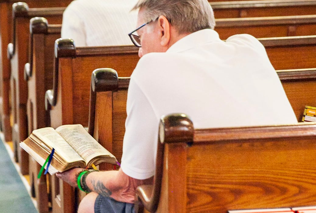 Parishioner Sitting in Pew Reading Bible