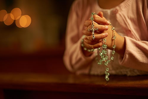 Woman Praying the Rosary
